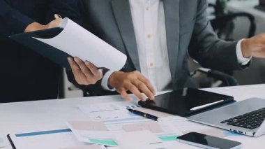 İş yerinde dizüstü bilgisayarı ve hesap makinesi olan bir iş adamı