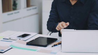 Ofiste çalışan iş adamı, dizüstü bilgisayarla çalışıyor.