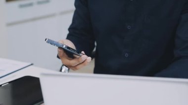 Akıllı telefon ve dizüstü bilgisayarlı genç işadamı, burayı kapatın.