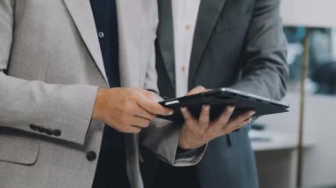 Yakın plan - modern ofiste iş adamlarının tablet kullanması ve kalemi ellerinde tutması. iş kavramı