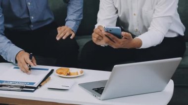 İş ekibi ofisteki dizüstü bilgisayarda birlikte çalışıyor..