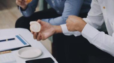 Genç işadamı ofisinde oturuyor ve kahve içiyor.