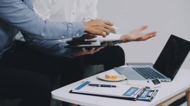 Genç işadamı ofiste iş ekibiyle birlikte çalışıyor..