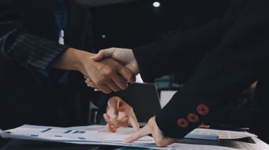 Modern ofiste iş adamları el sıkışıyor..