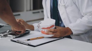 Doktor diş ve diş aletleri tutuyor..