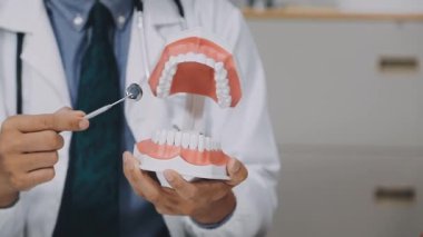 Elinde beyaz dişleri olan bir doktor.