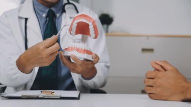 Diş kliniğinde dişlerini gösteren dişçi