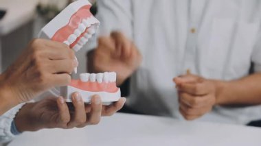 Hastaya dişlerini gösteren dişçi