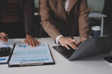 Muhasebe şirketi kazançlı nakit akışı için finansman ve vergilendirme planlaması, ofiste çalışan denetçi ve muhasebeci ekibi, mali verileri ve muhasebe kayıtlarını hesap makinesiyle analiz eder.