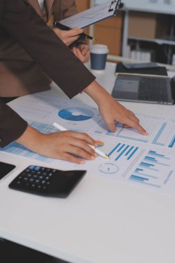 Muhasebe şirketi kazançlı nakit akışı için finansman ve vergilendirme planlaması, ofiste çalışan denetçi ve muhasebeci ekibi, mali verileri ve muhasebe kayıtlarını hesap makinesiyle analiz eder.