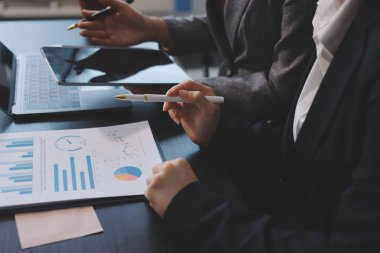 Muhasebe şirketi kazançlı nakit akışı için finansman ve vergilendirme planlaması, ofiste çalışan denetçi ve muhasebeci ekibi, mali verileri ve muhasebe kayıtlarını hesap makinesiyle analiz eder.