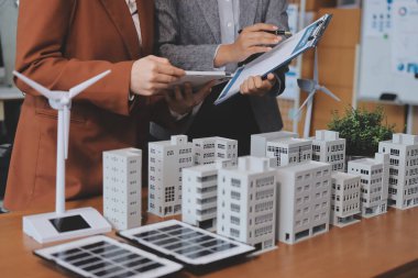 İş adamları arasında güneş pili paneli teknolojisi ve Güneş Enerjisi Çevre Kenti kavramındaki son gelişmeler üzerine tartışma.