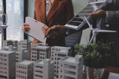 İş adamları arasında güneş pili paneli teknolojisi ve Güneş Enerjisi Çevre Kenti kavramındaki son gelişmeler üzerine tartışma.
