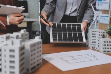 İş adamları arasında güneş pili paneli teknolojisi ve Güneş Enerjisi Çevre Kenti kavramındaki son gelişmeler üzerine tartışma.