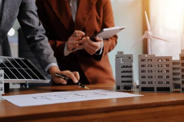 İş adamları arasında güneş pili paneli teknolojisi ve Güneş Enerjisi Çevre Kenti kavramındaki son gelişmeler üzerine tartışma.