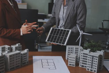 İş adamları arasında güneş pili paneli teknolojisi ve Güneş Enerjisi Çevre Kenti kavramındaki son gelişmeler üzerine tartışma.