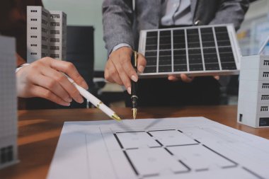 İş adamları arasında güneş pili paneli teknolojisi ve Güneş Enerjisi Çevre Kenti kavramındaki son gelişmeler üzerine tartışma.