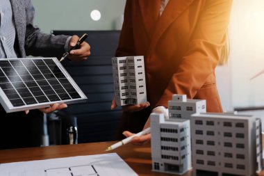 İş adamları arasında güneş pili paneli teknolojisi ve Güneş Enerjisi Çevre Kenti kavramındaki son gelişmeler üzerine tartışma.