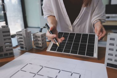 İş adamları arasında güneş pili paneli teknolojisi ve Güneş Enerjisi Çevre Kenti kavramındaki son gelişmeler üzerine tartışma.