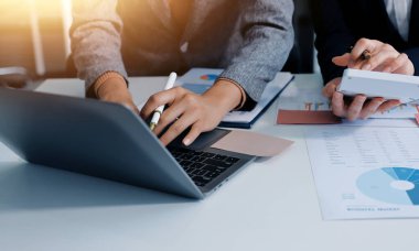 Muhasebe şirketi kazançlı nakit akışı için finansman ve vergilendirme planlaması, ofiste çalışan denetçi ve muhasebeci ekibi, mali verileri ve muhasebe kayıtlarını hesap makinesiyle analiz eder.