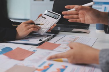 Muhasebe şirketi kazançlı nakit akışı için finansman ve vergilendirme planlaması, ofiste çalışan denetçi ve muhasebeci ekibi, mali verileri ve muhasebe kayıtlarını hesap makinesiyle analiz eder.