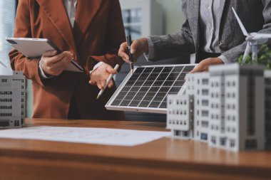 İş adamları arasında güneş pili paneli teknolojisi ve Güneş Enerjisi Çevre Kenti kavramındaki son gelişmeler üzerine tartışma.