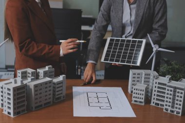 İş adamları arasında güneş pili paneli teknolojisi ve Güneş Enerjisi Çevre Kenti kavramındaki son gelişmeler üzerine tartışma.