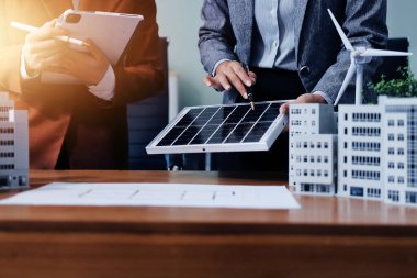 İş adamları arasında güneş pili paneli teknolojisi ve Güneş Enerjisi Çevre Kenti kavramındaki son gelişmeler üzerine tartışma.