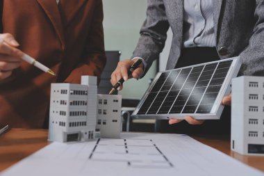 İş adamları arasında güneş pili paneli teknolojisi ve Güneş Enerjisi Çevre Kenti kavramındaki son gelişmeler üzerine tartışma.