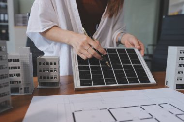 İş adamları arasında güneş pili paneli teknolojisi ve Güneş Enerjisi Çevre Kenti kavramındaki son gelişmeler üzerine tartışma.