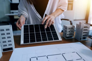 İş adamları arasında güneş pili paneli teknolojisi ve Güneş Enerjisi Çevre Kenti kavramındaki son gelişmeler üzerine tartışma.