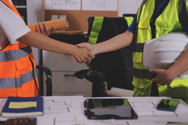Endüstriyel mühendislerden oluşan bir ekip, fabrikadaki masada bulunan makine planlarını analiz ediyor. Fabrikada ya da üretim tesisinde çalışıyorum..