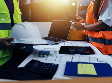 Endüstriyel mühendislerden oluşan bir ekip, fabrikadaki masada bulunan makine planlarını analiz ediyor. Fabrikada ya da üretim tesisinde çalışıyorum..