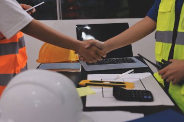 Endüstriyel mühendislerden oluşan bir ekip, fabrikadaki masada bulunan makine planlarını analiz ediyor. Fabrikada ya da üretim tesisinde çalışıyorum..