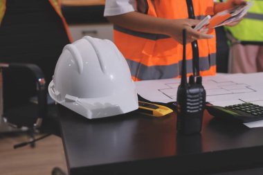 Endüstriyel mühendislerden oluşan bir ekip, fabrikadaki masada bulunan makine planlarını analiz ediyor. Fabrikada ya da üretim tesisinde çalışıyorum..