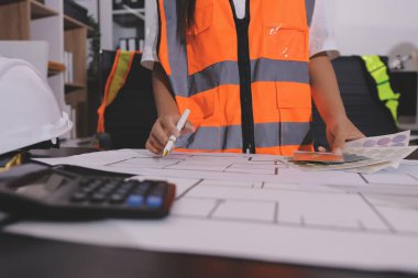Endüstriyel mühendislerden oluşan bir ekip, fabrikadaki masada bulunan makine planlarını analiz ediyor. Fabrikada ya da üretim tesisinde çalışıyorum..