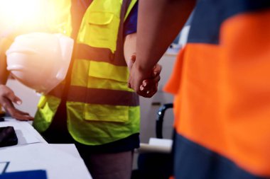 Endüstriyel mühendislerden oluşan bir ekip, fabrikadaki masada bulunan makine planlarını analiz ediyor. Fabrikada ya da üretim tesisinde çalışıyorum..