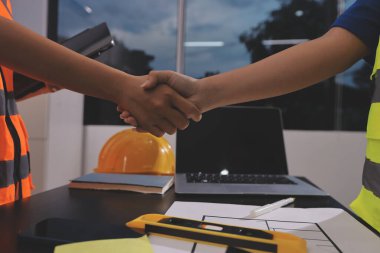 Endüstriyel mühendislerden oluşan bir ekip, fabrikadaki masada bulunan makine planlarını analiz ediyor. Fabrikada ya da üretim tesisinde çalışıyorum..