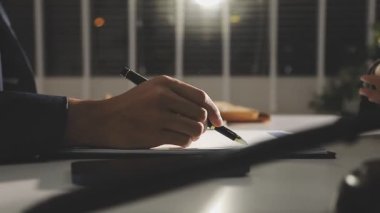 İşadamı geceleri deftere notlar yazıyor.