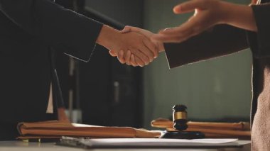 Modern bir ofiste iş adamları el sıkışır.