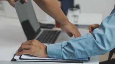 Genç iş adamı ofiste dizüstü bilgisayarla çalışıyor.