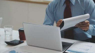 Resmi görevdeki genç iş kadını ofiste otururken dijital tablet kullanıyor