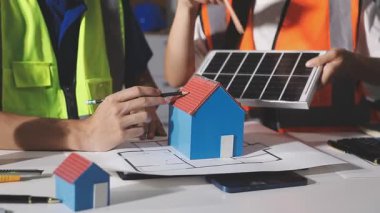 Genç bir mühendis ev modeli üzerinde çalışıyor. İnşaat, emlak konsepti