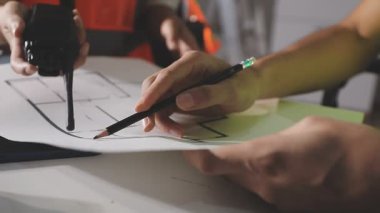 Ofis masasında proje üzerinde çalışan mühendis ya da mimar.