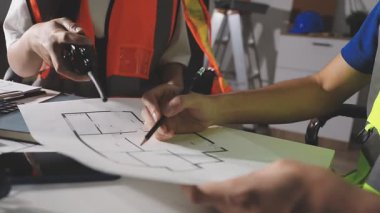 Ofiste planlar üzerinde çalışan mühendis ya da mimar