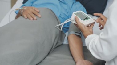 Doktor ofisteki hastanın kan basıncını ölçüyor, yakın plan.