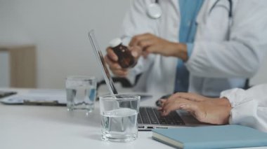 Doktor ofiste dizüstü bilgisayar kullanıyor..