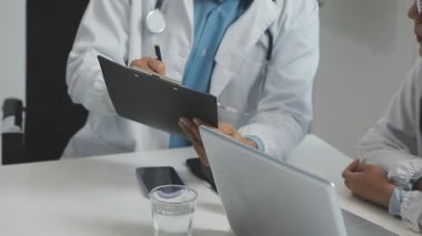 Ofisinde steteskoplu ve tabletli bir doktor var.