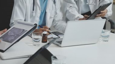 Tıbbi cihazları olan bir doktor ve hasta tablette bir şey tartışıyor.