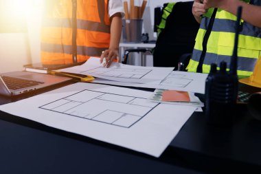 Endüstriyel mühendislerden oluşan bir ekip, fabrikadaki masada bulunan makine planlarını analiz ediyor. Fabrikada ya da üretim tesisinde çalışıyorum..